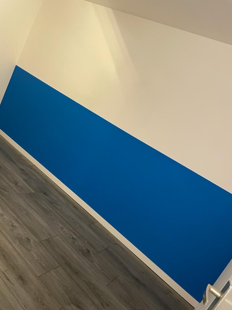 Wand met strakke blauwe accentband, netjes afgelakt
