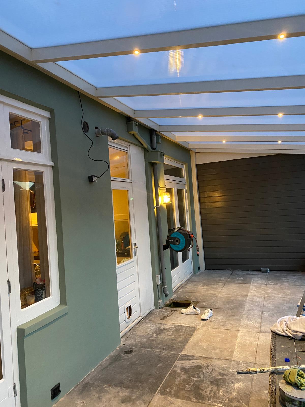 Buitenschilderwerk: groen geschilderde wand onder een sfeervol verlichte veranda