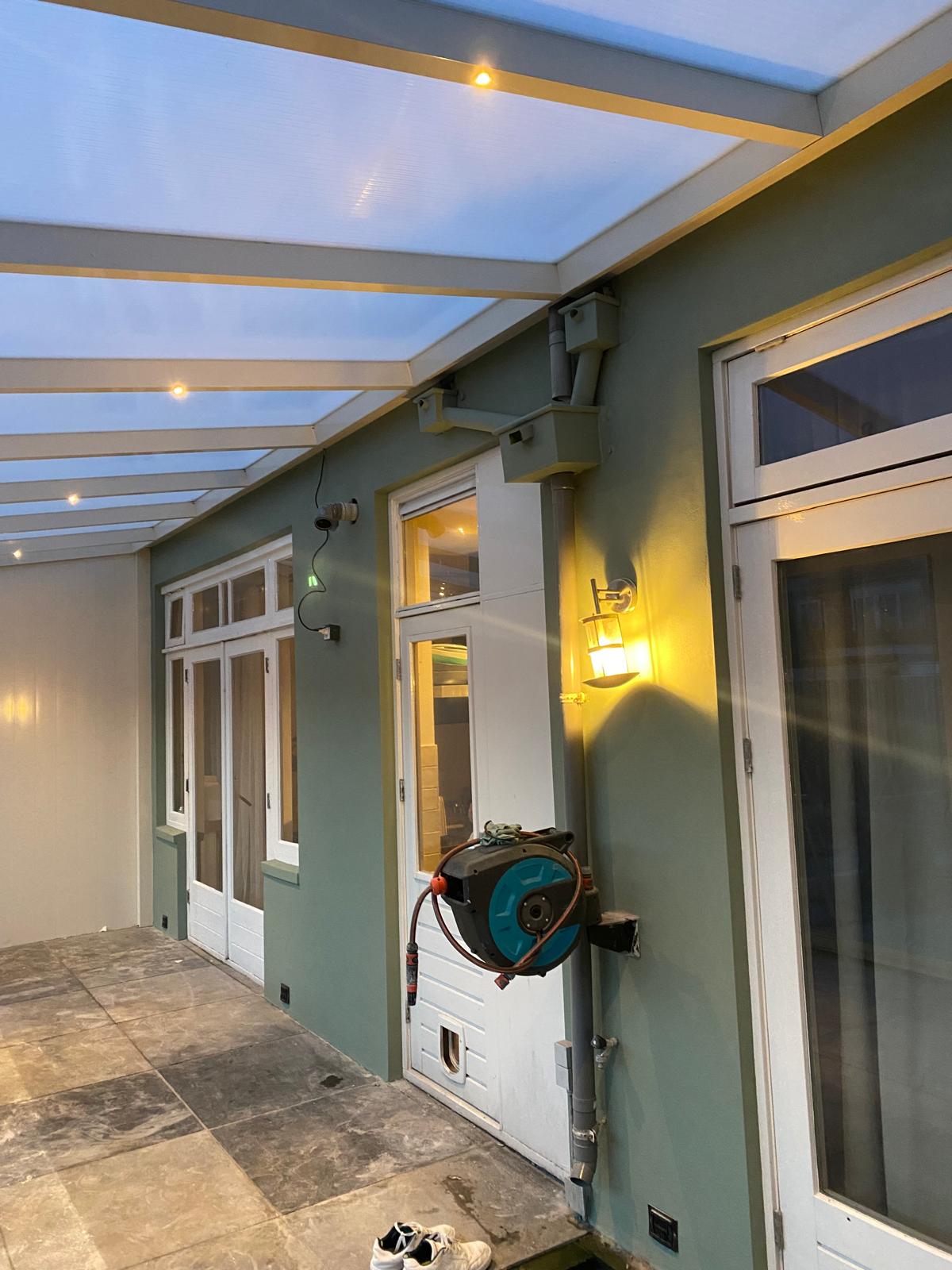 Sfeervol geschilderde veranda met groene wand en avondverlichting